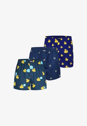 Tre par herre boxershorts i blå nuancer med mønstre af gule gummialler og gråænder.
