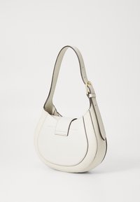 Biała skórzana torebka na ramię z zaokrągloną klapą i regulowanym paskiem, z ozdobnym zapięciem w kolorze złotym na pasku.