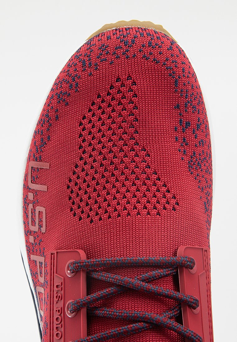Chaussure de sport rouge avec un dessus en maille respirant, des accents noirs, un motif texturé et un système de laçage. Logo U.S. Polo affiché.