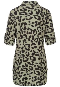 Chemise à manches longues avec poignets retroussés, base beige et imprimé léopard noir irrégulier, vue de dos.