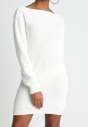 Robe pull blanche en maille, dotée d'un col rond, de manches longues et d'un design texturé et épais. L'ourlet se situe au-dessus du milieu de la cuisse.