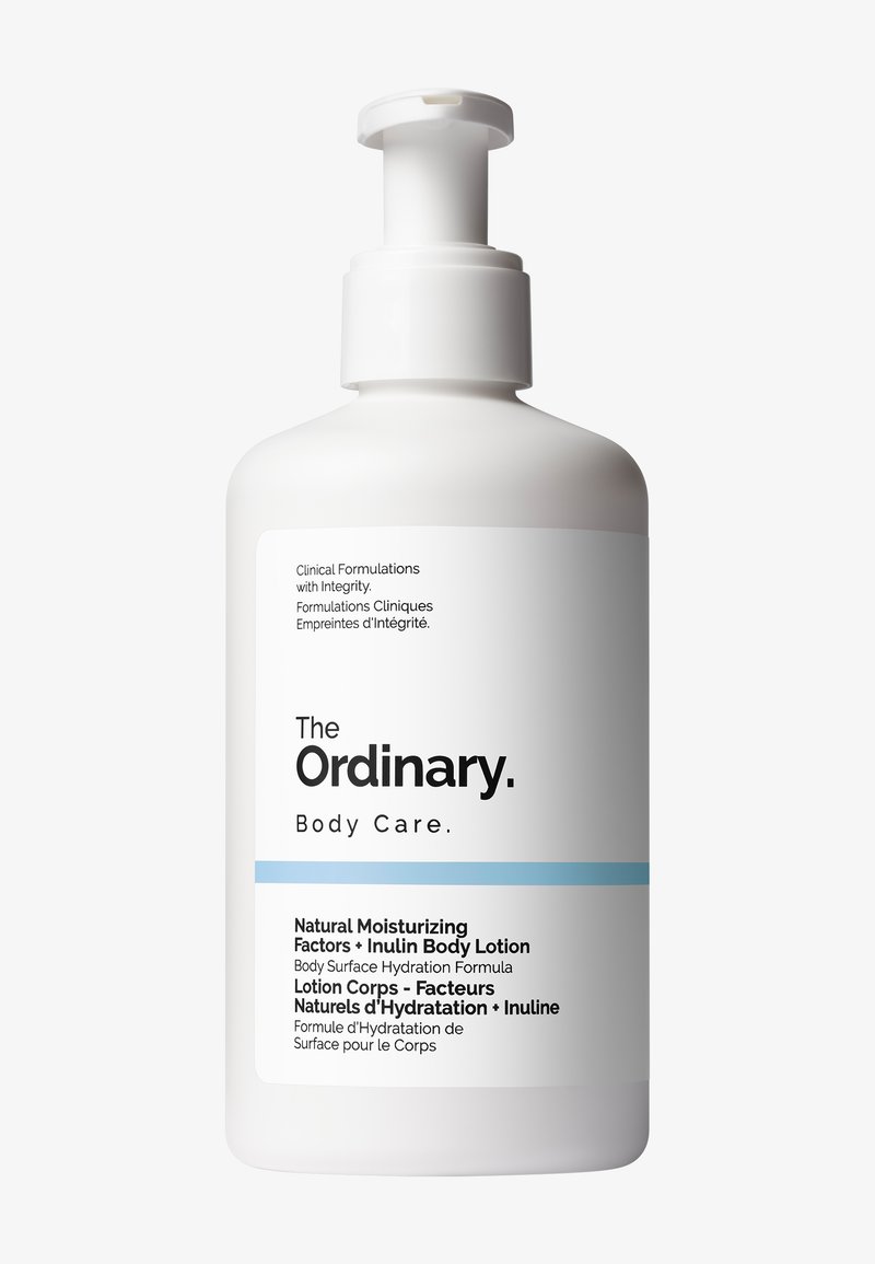 Biała plastikowa butelka z dozownikiem na pompę, charakteryzująca się minimalistycznym designem. Przednia etykieta zawiera nazwę produktu oraz opis w czarnym i niebieskim tekście.