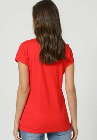 Camiseta corta roja de mangas cortas con un diseño ajustado, textura suave y escote redondeado, mostrada desde la parte trasera con un mínimo de detalles.