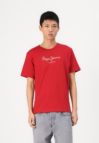 Camiseta de algodón roja con cuello redondo y mangas cortas, con el logo blanco "Pepe Jeans London" impreso en el frontal.
