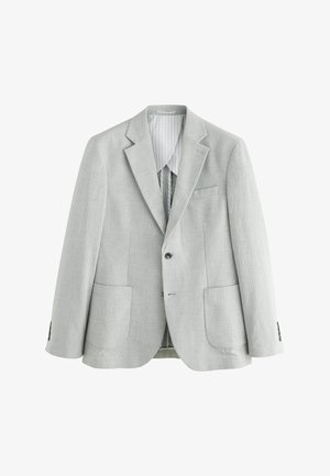 Hämaroheline bleiser, mis on valmistatud tekstureeritud kangast, omades nurgelisi krae, kahte esist taskut ja ühte nupuga sulgemist.