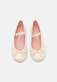 Ballet flats in pizzo avorio con una punta lucida. Presentano un fiocco in raso e una fascia elastica. Foderati in tessuto rosa. Design floreale testurizzato.