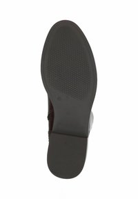Suela de zapato de goma marrón con patrón de agarre texturizado, puntera redondeada, tacón ligero, bordes suaves y detalles de talla en relieve visibles.