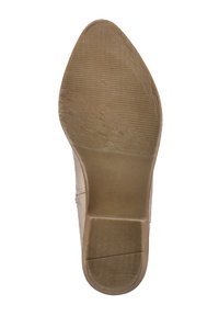 Suela de zapato de tacón alto beige con forma puntiaguda. La superficie de goma texturizada presenta ranuras lineales y una sección de tacón suave.