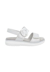 White sandal featuring perforated upper material, adjustable strap with a circular buckle, and cushioned sole. Flat and lightweight design.