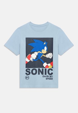 Light blue t-shirt with graphic of Sonic the Hedgehog running, featuring text "SONIC," Japanese characters, and the word "SPEED" below.
