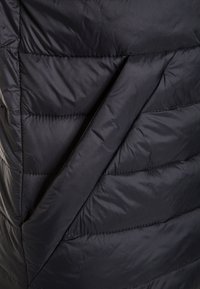 Czarna kurtka puchowa z pikowanym wzorem z ukośnym przeszyciem i zakładanym panelem, wykonana z gładkiej, lekkiej tkaniny.