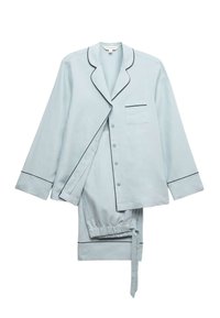 Lyseblåt pyjamasæt med en knap-op-overdel med sorte kantninger og en brystlomme, kombineret med bukser med elastik i taljen. Blød stofstruktur.