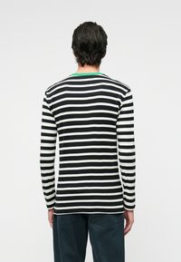 Langermet stripete skjorte i svart og hvitt med en grønn krage. Myk stoff, strak passform, og kontrasterende horisontale striper.