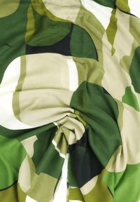 Tessuto verde e beige con motivi astratti; texture morbida, leggero, finitura liscia, con accenti scuri e caduta fluida.