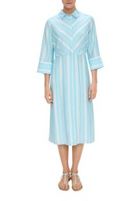 Himmelblaues Hemdkleid mit vertikalen weißen Streifen, Kragen, Dreiviertelärmeln und Länge bis zur Mitte der Waden. Sandalen sichtbar.