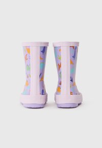 Bottes de pluie en caoutchouc violet avec des motifs de dinosaures multicolores. Semelles texturées et design flexible pour un chaussant facile. Doublure intérieure lisse.