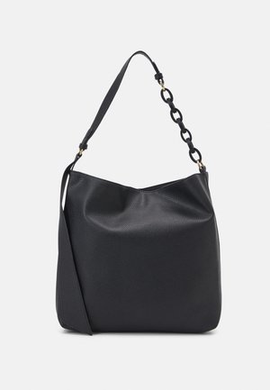 Sac à main en cuir noir texturé avec une large bandoulière et des maillons de chaîne décoratifs d'un côté sur un fond uni.