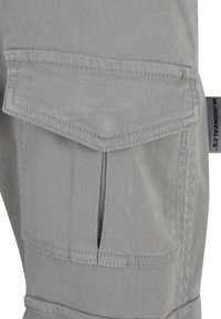 Pantaloni cargo gri, cu un buzunar frontal mare cu clapetă, cusături întărite și un design slim-fit. Realizați dintr-un material durabil din amestec de bumbac.