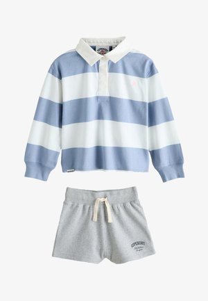 Koszulka do rugby z długim rękawem w niebiesko-białe paski, połączona z jasnoszarymi szortami z troczkami, obie marki Superdry.
