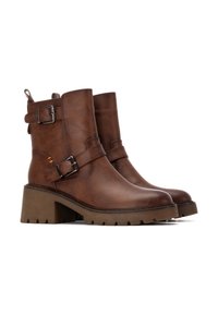 Stivaletti in pelle marrone con dettagli in metallo argentato, suole spesse e testurizzate e tacco chunky. Cuciture decorativi sulla parte superiore.
