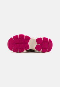 Suola di scarpa con una intersuola bianca e una suola in gomma rosa vivace con modelli esagonali per la trazione.