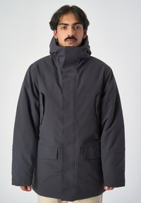 Schwarze isolierte Winterjacke mit hohem Kragen, Reißverschluss und zwei Fronttaschen. Glattes Material mit minimalistischem Design und Logodetail.