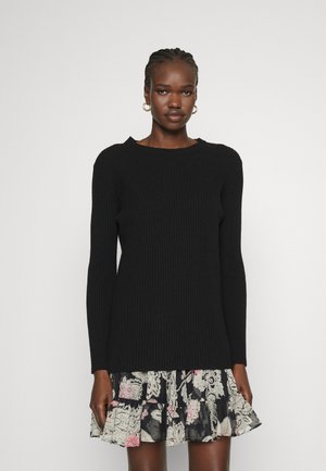 Μαύρο πλεκτό πουλόβερ με ραβδώσεις, μακρύ μανίκι, στρογγυλή λαιμόκοψη και υφή, συμπληρωμένο από φούστα με λουλουδάτο μοτίβο και βολάν.