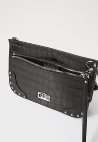Clutch bag nera in similpelle effetto coccodrillo, con tasca con zip, hardware in argento, dettagli con borchie e tracolla removibile. Presenta un interno marchiato.
