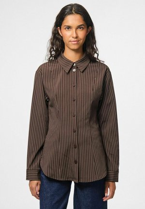 Chemise à boutons marron avec des rayures blanches verticales, dotée d'un col classique, de manches longues et d'une coupe ajustée. Tissu au toucher lisse.