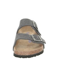 Sandale en suède gris à deux brides avec boucles en argent, semelle en liège naturel, semelle extérieure en caoutchouc noir texturé, design à bout ouvert.