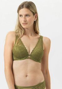 Soutien-gorge vert olive avec un motif géométrique texturé, présentant un décolleté en V profond, des bords festonnés et une fermeture à clip à l'avant.