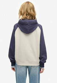 La felpa con cappuccio presenta un design a blocchi di colore con corpo beige e maniche navy. Realizzata in un tessuto morbido con polsini e orlo a coste.