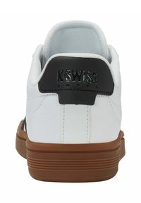 Sneaker alb cu tabără de călcâi din piele neagră, talpă din cauciuc maro, guler căptușit și căptușeală din material texturat. Prezintă logo-ul "K-Swiss" pe călcâi.