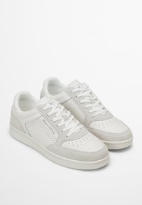Sneaker bianche con dettagli in pelle liscia e suède, decorazioni perforate e lacci piatti. Branding sottile sul lato. Design low-top.