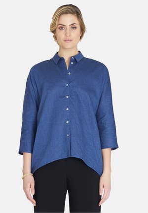Blaue Leinenbluse mit Kragen, Knopfleiste, 3/4-Ärmeln und abgerundetem Saum. Der Stoff hat eine strukturierte Oberfläche.