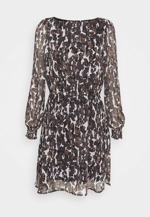 Czarna i biała sukienka z długim rękawem z abstrakcyjnym zwierzęcym wzorem, taliowana, z lekko przejrzystą tkaniną na rękawach i dolnym brzegu.