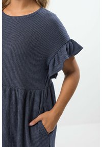 Kleid in Marineblau mit kurzen Ärmeln, geripptem Muster, Rüschensäumen und einem gerafften Taillenbereich, ausgestattet mit seitlichen Taschen.