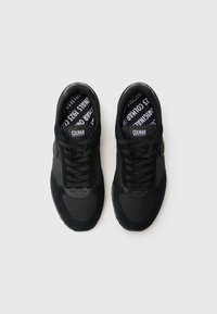 Schwarze Sneakers aus einer Kombination von Wildleder und Mesh-Materialien. Abgerundete Zehenform, flache Schnürsenkel und gepolsterte Innensohle mit Logo.