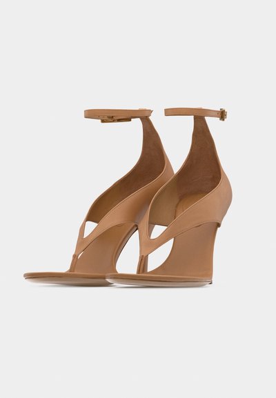 Ζευγάρι ταμπά πλατφόρμες με λουριά στον αστράγαλο και ανοιχτό σχέδιο στο μπροστινό μέρος, παρουσιασμένα σε απλό ανοιχτό φόντο.