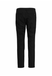 Pantaloni neri con una texture liscia, vita elastica e due tasche posteriori. Fit sartoriale con estremità delle ginocchia arrotondate e gambe tapered.