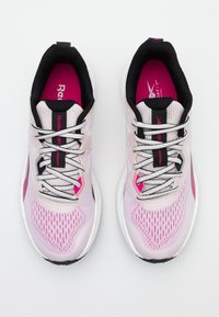 Ljusrosa sportskor med en andningsbar meshtopp, svarta accenter, vit mellansula och texturerad gummisula. Har rosa logotyp och snören.