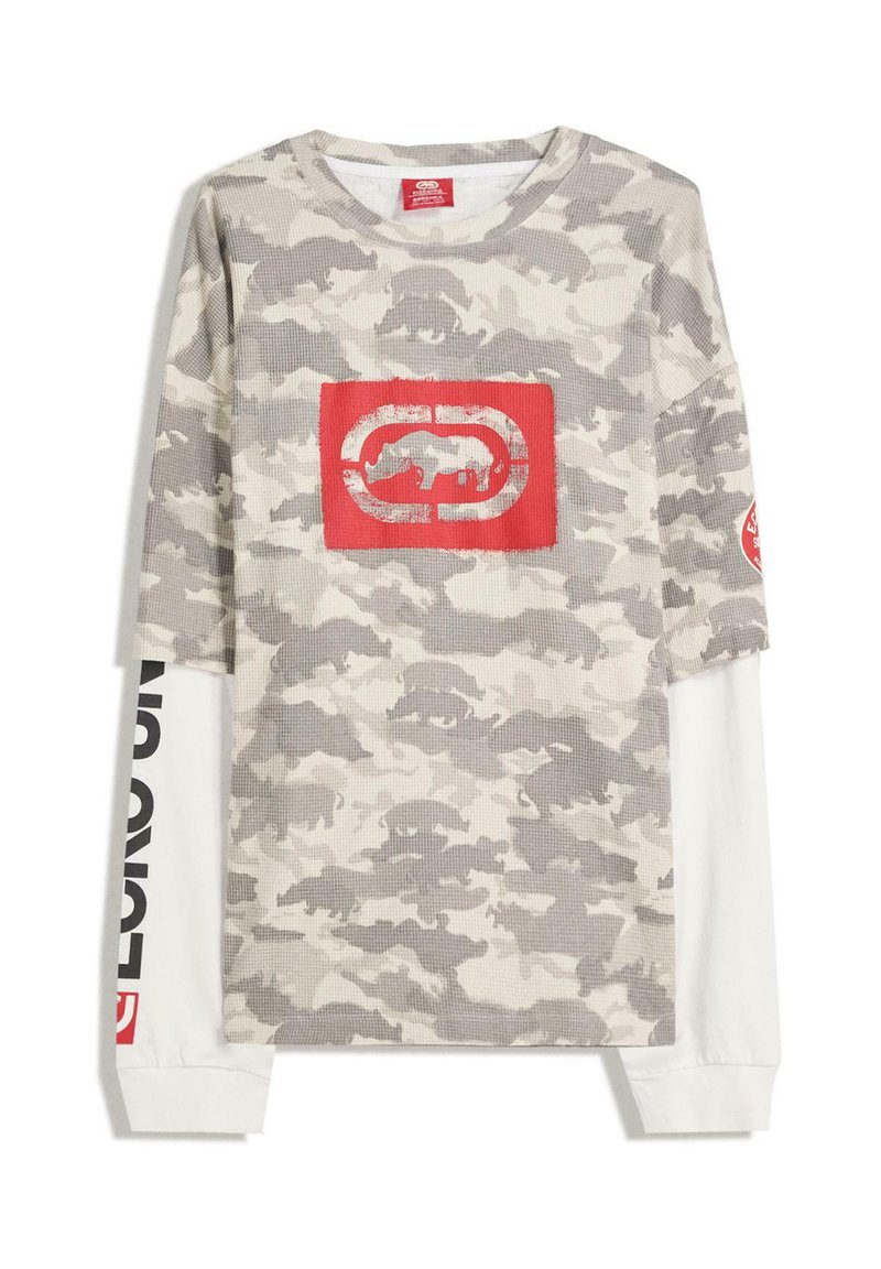 Camicia a maniche lunghe in camuffamento beige e grigio, con un logo grafico rosso sul davanti e scritte nere lungo le maniche bianche. Tessuto strutturato.