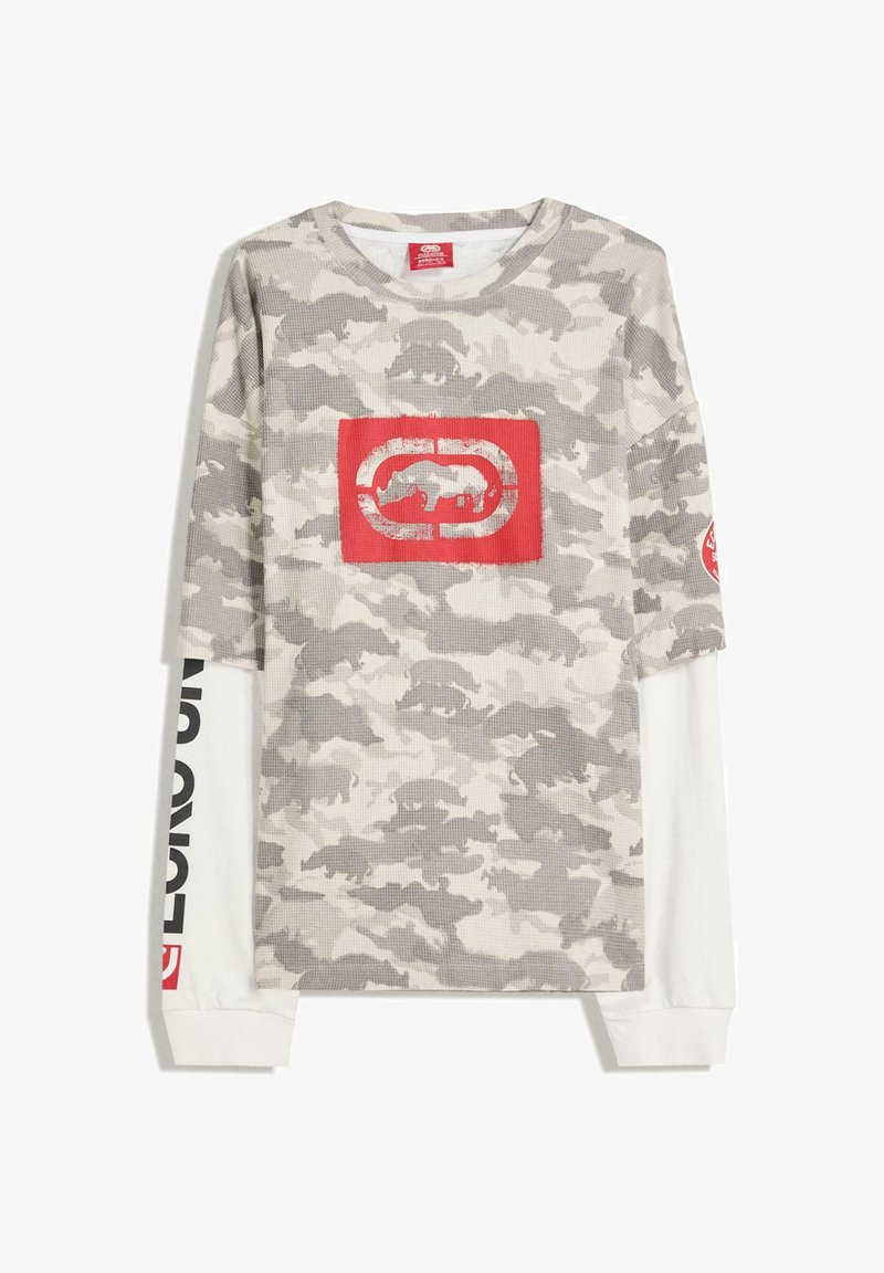Camicia a maniche lunghe in camuffamento beige e grigio, con un logo grafico rosso sul davanti e scritte nere lungo le maniche bianche. Tessuto strutturato.