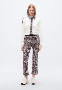 Λευκό φούτερ με γιακά και μπροστινό πάνελ σε σχέδιο λεοπάρδαλης, συνδυασμένο με παντελόνια με το ίδιο σχέδιο λεοπάρδαλης. Casual εφαρμογή με ελαστική μέση.