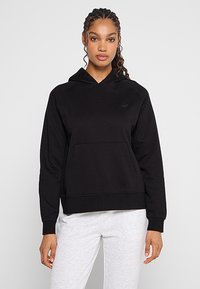 Czarna, polarowa bluza z kapturem wykonana z mieszanki bawełny, z przedni�ą kieszenią i subtelnym logo. Gładka faktura z ściągaczami przy mankietach i u dołu.