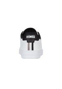 Bílé tenisky s černým a šedým pruhem na patě; mají texturovaný bílý materiál, polstrovaný límec a logo K-Swiss na zadní straně.