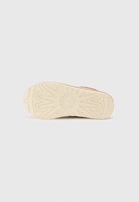 Zool van een sneaker met een gemarmerd crème rubber materiaal, voorzien van een uniek profiel en een ronde logodetail.