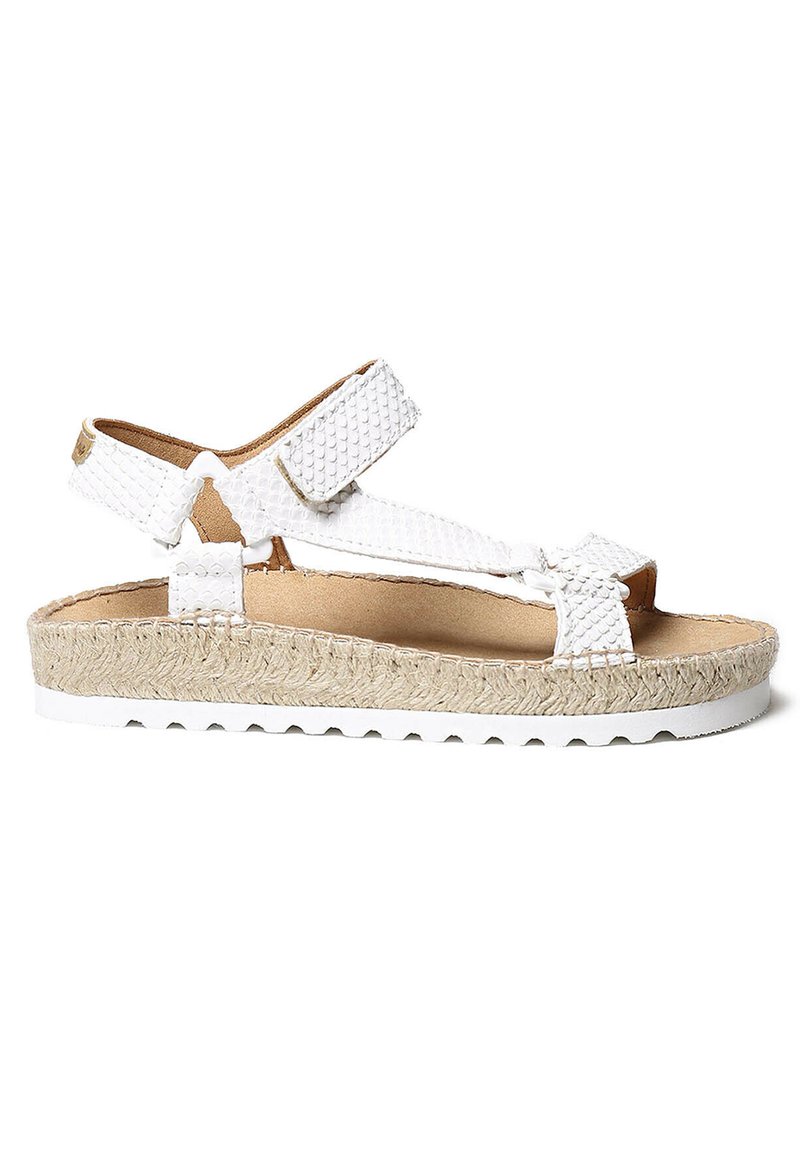 White woven sandals with adjustable straps, textured upper, and a jute-wrapped platform. Rubber sole and cushioned footbed for comfort.