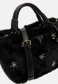 Borsa in pelliccia sintetica nera con duplice manici in pelle nera e una tracolla removibile. Decorata con embellishments floreali e un logo a forma triangolare.