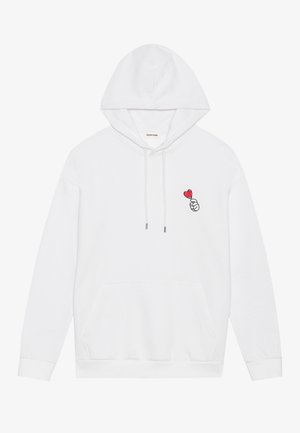 Bjela dukserica s kapuljačom, dugim rukavima i prednjim džepom, s malim crvenim grafičkim otisakom ruke u obliku srca na lijevoj strani prsnog područja.